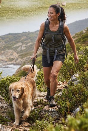 A woman hiking with a golden retriever